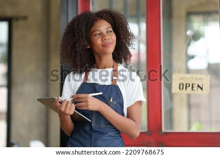 Smiling woman business owner standing waiting to open the shop waiting to receive customer service and opening a store sign.