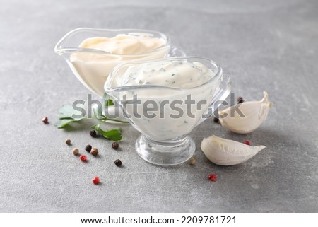 Garlic sauce and ingredients on gray textured background