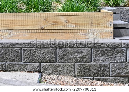 Concrete block wall with a pine sleeper garden bed Royalty-Free Stock Photo #2209788311