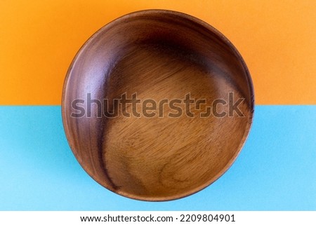 asian wooden bowl, wooden plate, with chopsticks and without on Abstract pastel colored paper, light orange, light blue, white, orange