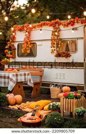 The campsite is decorated in autumn colors. Pumpkins and many bright flowers close-up. Guitars lie on a yellow plaid
