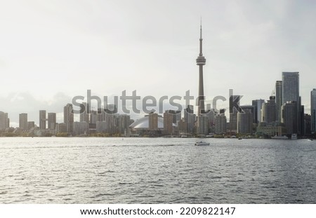 The Toronto skyline on a cloudy spring day. A boat passes by in the distance.