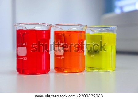 The beakers glassware on bench laboratory with red orange, yellow, colorful solvent from titration experiment. Parameter of acidity and alkalinity, acid-base analysis compounding in wastewater sample. Royalty-Free Stock Photo #2209829063