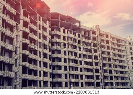 new beautiful buildings under construction stand on a background of beautiful sky. Construction concept