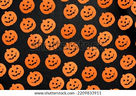 Halloween background. Orange pumpkins with carved smiles on black fabric.