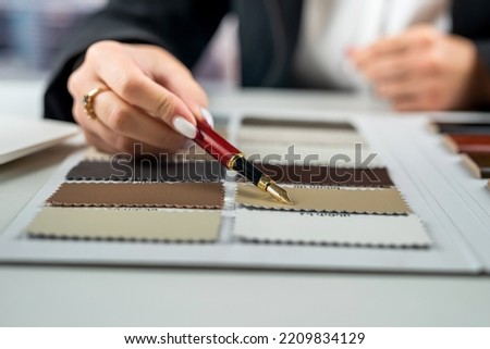 Male architect or interior designer holding wooden samples with hands choosing wood material for residential project. Sample for furniture design. Architecture and construction