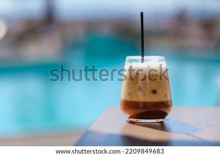 Closeup view of an iced greek  coffee, also known as freddo cappuccino with a straw in Ios Greece