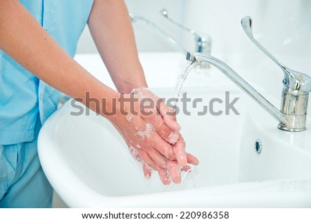 Male surgeon washes his hands before the operation Royalty-Free Stock Photo #220986358
