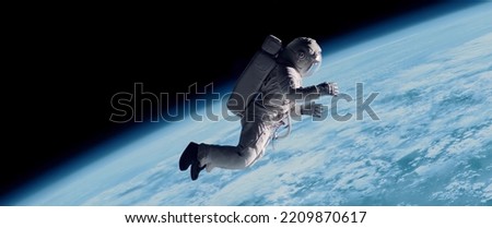 Full portrait of Caucasian female astronaut during spacewalk, planet Earth in the background. Shot with 2x anamorphic lens Royalty-Free Stock Photo #2209870617
