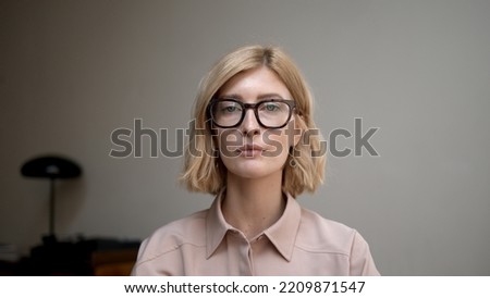 Portrait of blonde woman in eyeglasses smiling. Attractive stylish adult person looking at the camera with sincere and happy smile. Concept of good mood. Royalty-Free Stock Photo #2209871547