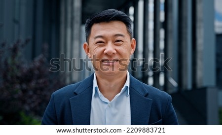 Close up front view in city outdoors Asian Korean man business boss leader company CEO smiling glad happy middle-aged businessman professional financial advisor executive leader manager male lawyer Royalty-Free Stock Photo #2209883721