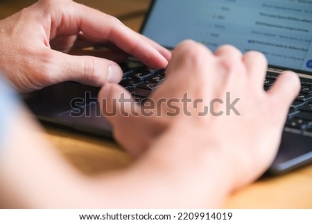 Hands typing on laptop against the screen