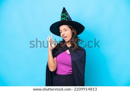 Young hispanic woman dressed as witch over isolated background showing ok sign with fingers