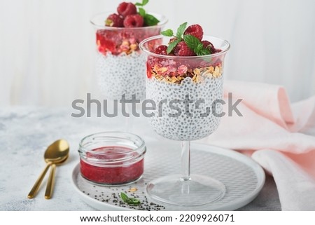 Chia pudding. Healthy vanilla chia pudding in glass with fresh raspberries and mint on white background. Vegan healthy breakfast. 