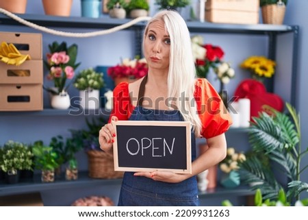Caucasian woman working at florist holding open sign depressed and worry for distress, crying angry and afraid. sad expression. 