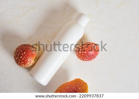bottle of cream or ointment and fly agaric, medicinal properties of fly agaric for cosmetics and drugs, fly agaric extract Royalty-Free Stock Photo #2209937837