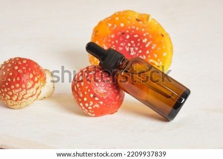 fly agaric red and amber glass dropper bottles, fly agaric extract for skin and joints treatment, fly agaric microdosing, biohacking to improve the state of the body and mind Royalty-Free Stock Photo #2209937839