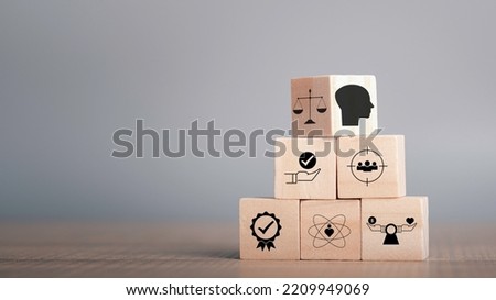 Ethics inside human mind, Business ethics concept. Ethics inside a head symbols in wooden cubes stacked on gray background with copy space.