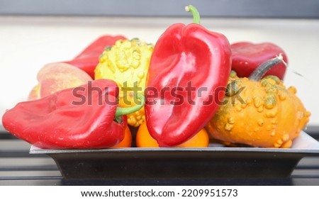 Closeup picture with veriety of autumnal fruit and vegetables like red peppers,yellow pumpkins, peaches and apples