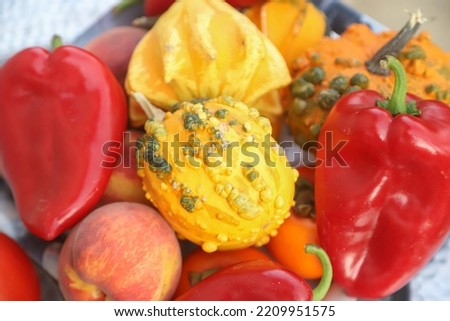 Closeup picture with veriety of autumnal fruit and vegetables like red peppers,yellow pumpkins, peaches and apples