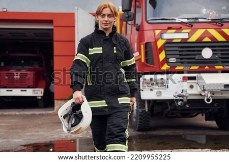 Walking forward. Woman firefighter in uniform is at work in department.