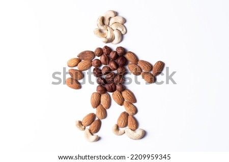 Figure of cashew and almond nuts in the shape of a man. Symbol of natural healthy food. Isolated figure on a white background.