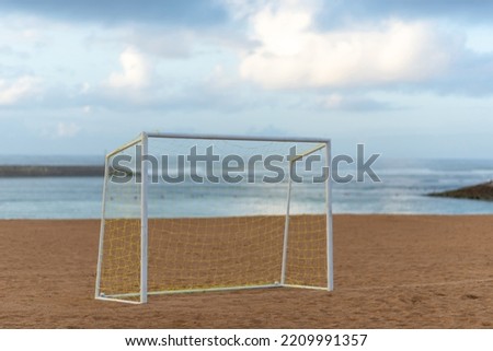 Soccer goal on sunset beach.