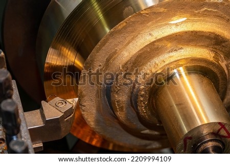 Closeup scene the lathe machine rough cut the brass parts by lathe tools. The metalworking process by turning machine.