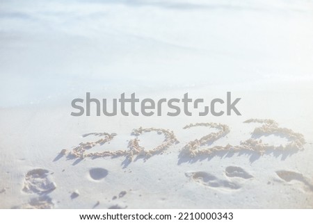 2023 new year inscription on sand at the beach.