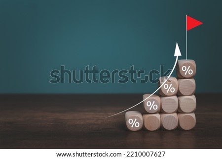 Interest financial  rate and mortgage rates concept, Wooden blocks with Icon percentage symbol and arrow pointing up. The economy is improving.