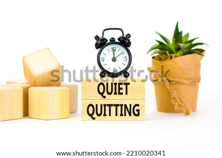 Quiet quitting symbol. Concept words Quiet quitting on wooden blocks. Beautiful white table white background. Black alarm clock. House plant. Business and quiet quitting concept. Copy space. Royalty-Free Stock Photo #2210020341