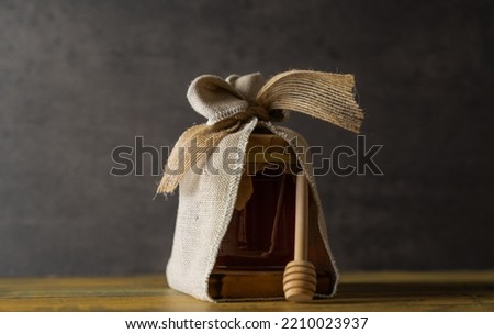 Honey jar decorated on a wooden block and with honey stick