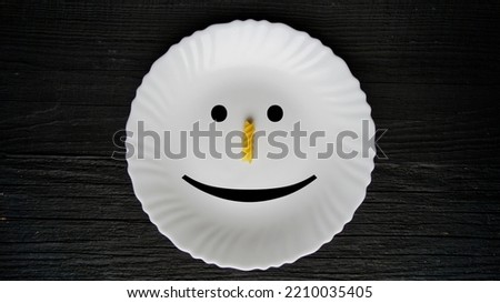 White plate, lies on a black background, smile