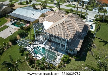 Hurricane Ian destroyed house in Florida residential area. Natural disaster and its consequences Royalty-Free Stock Photo #2210039789