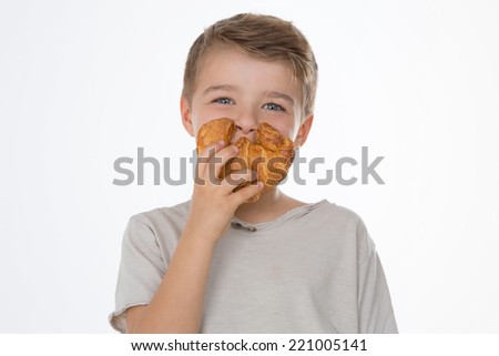 kid smiles while showing a croissant