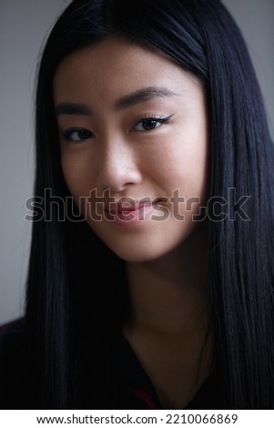 Portrait of beautiful Vietnamese girl. Headshot of cute Asian female person. Stock photo of pretty young woman from southeast asia in good mood. 