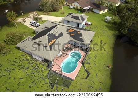 Hurricane Ian destroyed house roof in Florida residential area. Natural disaster and its consequences Royalty-Free Stock Photo #2210069455