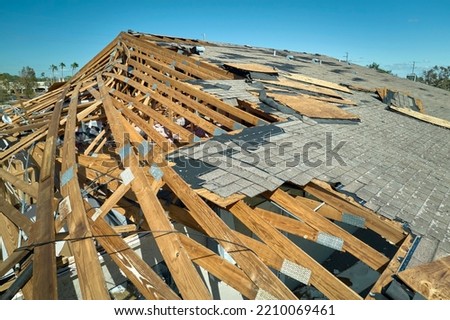 Hurricane Ian destroyed house roof in Florida residential area. Natural disaster and its consequences Royalty-Free Stock Photo #2210069461