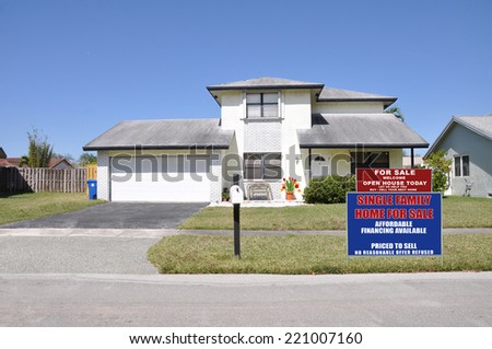 Real Estate for Sale Open house welcome sign on front yard lawn of suburban home residential neighborhood USA clear blue sky