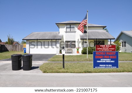 American Flag pole Real Estate for Sale Open house welcome sign on front yard lawn of suburban home residential neighborhood USA clear blue sky