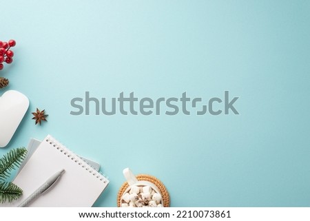 Winter concept. Top view photo of computer mouse cup of cocoa with marshmallow on placemat notepad anise mistletoe berries and spruce branch on isolated pastel blue background with copyspace