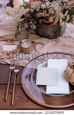 Detail of rustic table arrangement styled in natural browns and pastel pink tones, with blank place card and menu card templates Royalty-Free Stock Photo #2210078405