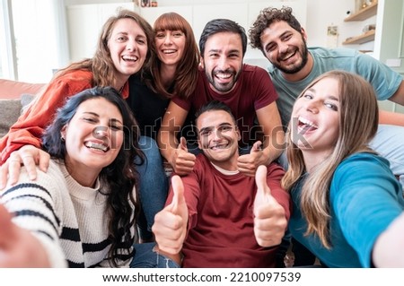 Group of friends having fun at home while taking selfie 