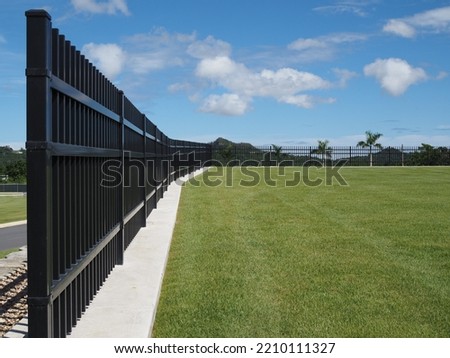 Black Aluminum Fence 3 Rails, beautiful green turf and background Royalty-Free Stock Photo #2210111327