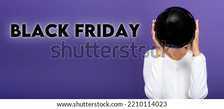 Black friday sale concept. Woman holding black balloon isolated on dark violet purple background 