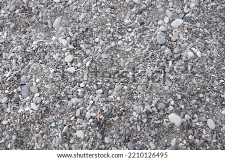 Texture of pebbles from the sea shore bank beach. Many pebbles from sea shore background