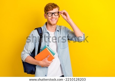 Photo of cheerful positive boy arm touch eye accessory good choice before study september empty space isolated on yellow color background