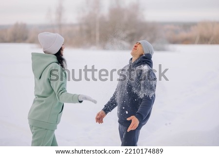 Happy couple playing winter game in forest outdoors. Love and leisure concept. High quality photo
