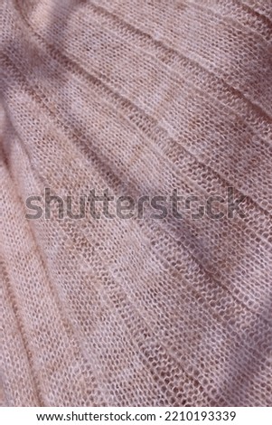 Pink-beige knitted material. Cozy background.