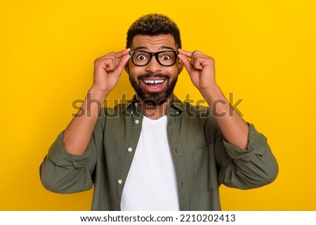 Photo of attractive excited man wear khaki shirt arms spectacles smiling isolated yellow color background Royalty-Free Stock Photo #2210202413